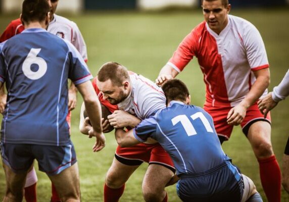 Group of aggressive sportsmen playing rugby match on a stadium. Large group of rugby players playing a match on a stadium.